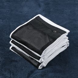 A golf towel folded neatly in white and black, featuring a zippered pocket and a logo.