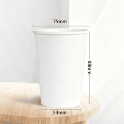 A disposable kraft paper cup, sized 9 oz, in white, with dimensions marked on the side, placed on a wooden surface.