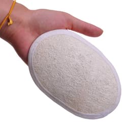 An exfoliating loofah sponge pad held in a hand, featuring a textured white surface and a circular shape.
