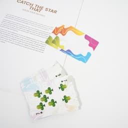 A set of black core playing cards featuring colourful designs, partially fanned out on a flat surface with a card above them.