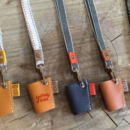 PU leather eyeglasses neck holders in tan, dark brown, and orange, each with a unique design. Features various strap colours.