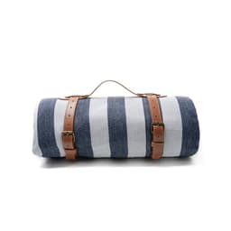 A striped picnic blanket in navy and white, featuring leather carry handles and buckles for easy transport.