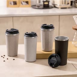 A collection of eco-friendly reusable coffee cups in grey, light grey, and black, each with a lid.