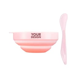 A pink facial mask mixing bowl set featuring a bowl and a matching spatula. The bowl has a logo area.