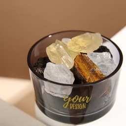 A crystal stone aromatherapy essential oil diffuser with clear and yellow stones in a black container. It features branding.