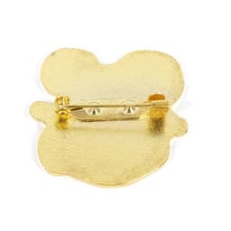 A gold metal lapel pin featuring a sturdy pin mechanism on the back. The surface has a textured finish.