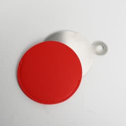 A red PU leather cosmetic mirror with a metal backing, featuring a loop for easy handling.