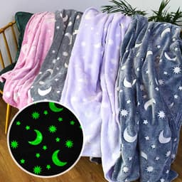 A collection of soft blankets in pink, grey, and lilac, featuring glow-in-the-dark moon and star patterns.