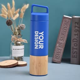 A drink bottle with a blue upper section and a bamboo base, featuring a handle and a logo.