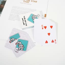 Custom PVC playing cards featuring a colourful design, with a red five of hearts displayed and a branded box.