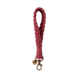 A pink macrame phone wrist strap with a metal clasp and a decorative logo charm.
