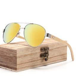 Classic bamboo temples sunglasses with a reflective gold lens, resting on a wooden box. The design is stylish and modern.