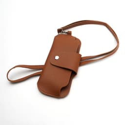 A brown portable glasses pouch with a strap, featuring a snap closure and a textured finish.