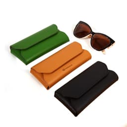 A collection of three PVC leather glasses cases in green, tan, and black, alongside a pair of sunglasses.