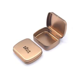 A gold metal hinged box container with a smooth interior and a logo printed on the lid.