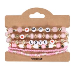 A set of clay bead friendship bracelets in pink tones, featuring beads with letters and decorative accents.