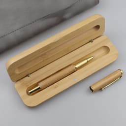 A bamboo fountain pen with a gold trim, nestled in a wooden gift box. The set has a natural finish.