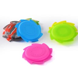 Four brightly coloured flying discs in pink, blue, green, and patterned designs. Each disc features a circular shape with slots.