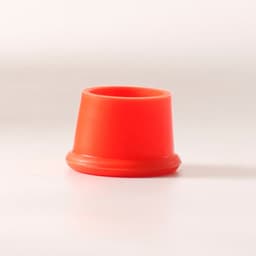 A bright red reusable silicone wine stopper with a round base and tapered top. It has a smooth finish.