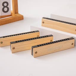 Custom wooden harmonicas in a light wood finish, featuring a design area and a black grille, displayed on a white surface.