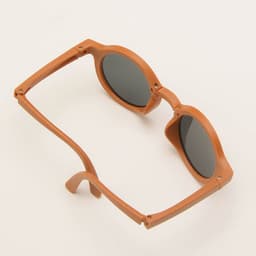 Foldable sunglasses in a warm brown colour with dark lenses, featuring a simple design and a logo.