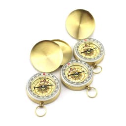 A set of three brass compasses with a clear face, featuring directional markings and a protective lid.