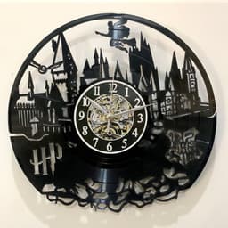 A black wall clock featuring intricate cutouts of a skyline with a flying figure, showcasing a vintage design.
