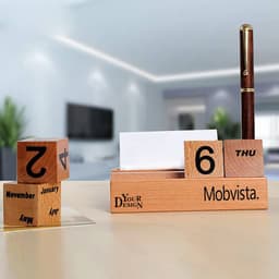 A wooden perpetual calendar featuring a pen holder, with blocks to display the date and month. The design includes a logo.