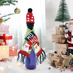 A drink bottle dressed in a red and green knitted hat and scarf, featuring festive patterns, set in a holiday-themed scene.
