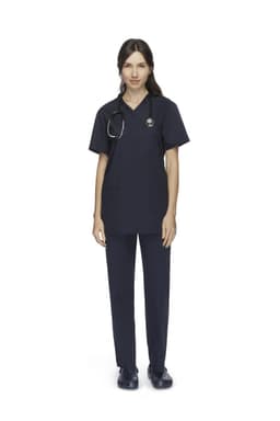 A woman wearing navy unisex scrub pants and a matching top, paired with a stethoscope. The outfit features pockets and a logo.