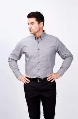 A long-sleeve grey button-up shirt with a collar, featuring a logo, worn by a man standing with hands on hips.