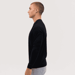 A long sleeve tee in black, featured on a model in profile view, showcasing a simple and sleek design.