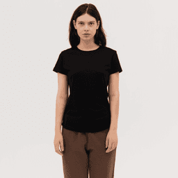 A black women's essential tee with a classic fit, paired with brown pants. The design features a logo on the shirt.