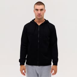 A black zip-up hooded sweatshirt with long sleeves, displayed on a model wearing grey pants.