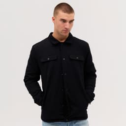 A black Studio Canvas Jacket with a collared neck and button closure, featuring two front pockets.
