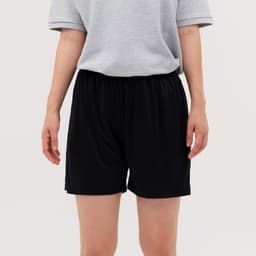 Black shorts displayed on a person, paired with a grey shirt, featuring an elastic waistband.