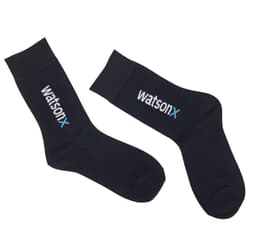 A pair of black socks featuring a logo, with a ribbed top and a smooth finish.