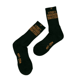 Black socks featuring a logo and text in gold, with a ribbed design and a crew length.