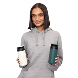 A drink bottle in white and teal, featuring a logo, held by a person in a grey hoodie.