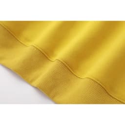 A close-up of a yellow hoodie, highlighting the soft fabric and ribbed cuff details. It features a branding logo.