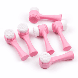 A set of six pink facial cleansing brushes with varying textured heads for skincare.