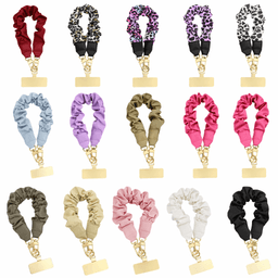 A collection of elastic hair scrunchies in various colours and patterns, featuring gold clips for securing.