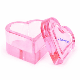 A pink heart-shaped box with a clear lid, featuring a branding logo on the side. 