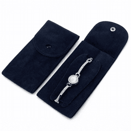A navy blue travel jewelry storage case with a clasp, holding a silver bracelet inside. Features a logo.