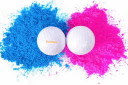 A pair of white golf balls positioned between vibrant blue and pink powders, with a logo on one ball.