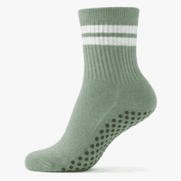A green ankle sock with white stripes and a textured, dotted grip pattern on the sole. It has a ribbed upper.