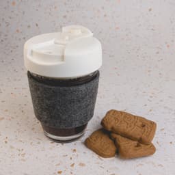 A reusable coffee cup with a white flip lid and grey RPET band, accompanied by three biscuit cookies.