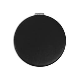 A round, black compact mirror with a textured finish and a silver clasp. It features a logo on the surface.