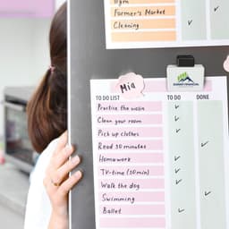 A magnetic clip in white and black, holding a colorful to-do list on a board, featuring a logo.