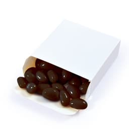 A box of black jelly beans is partially opened, with several beans spilling out onto a white background.